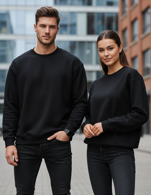 Male and female models wearing oversized black sweatshirts in urban setting